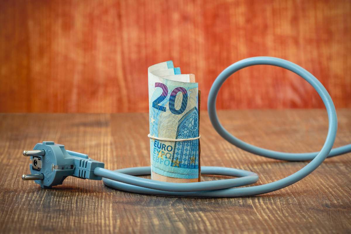 Mazzetta di banconote da 20€ e presa della corrente intorno
