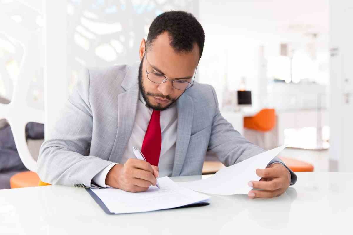 Uomo scrive alla scrivania