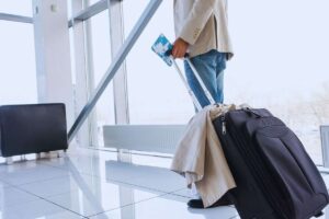 Viaggiatore che cammina in aeroporto con trolley