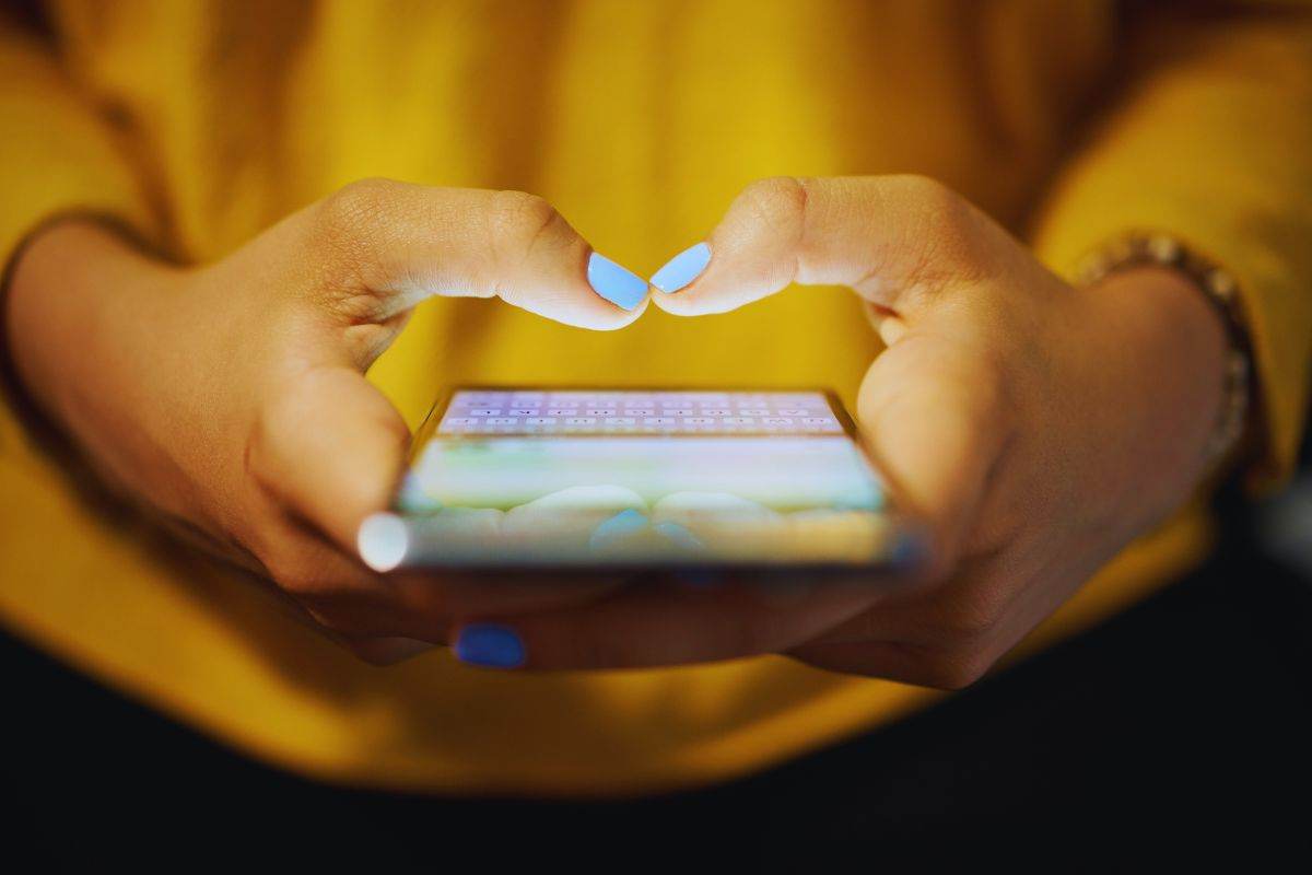 Ragazza che scrive messaggio su smartphone