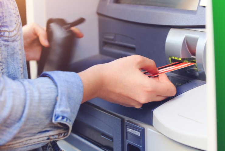 Ragazza che inserisce la carta nello sportello bancomat