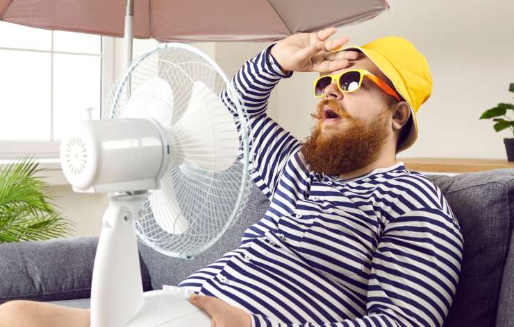 uomo sul divano con ventilatore
