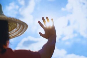 persona copre il sole con una mano