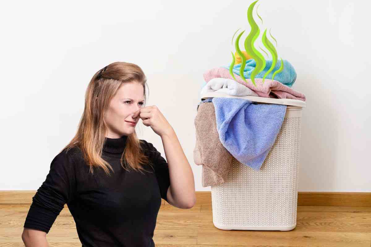 donna che si tappa il naso, cesta dei panni sporchi e cattivi odori