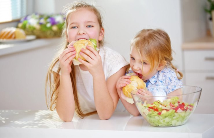 due bambine che mangiano dei panini
