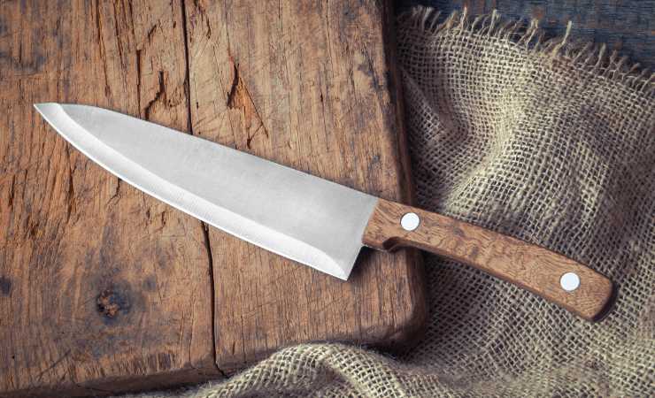 Coltello da cucina con manico in legno su un tagliere