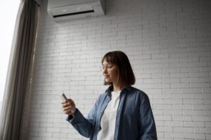 Ragazza con in mano il telecomando del condizionatore